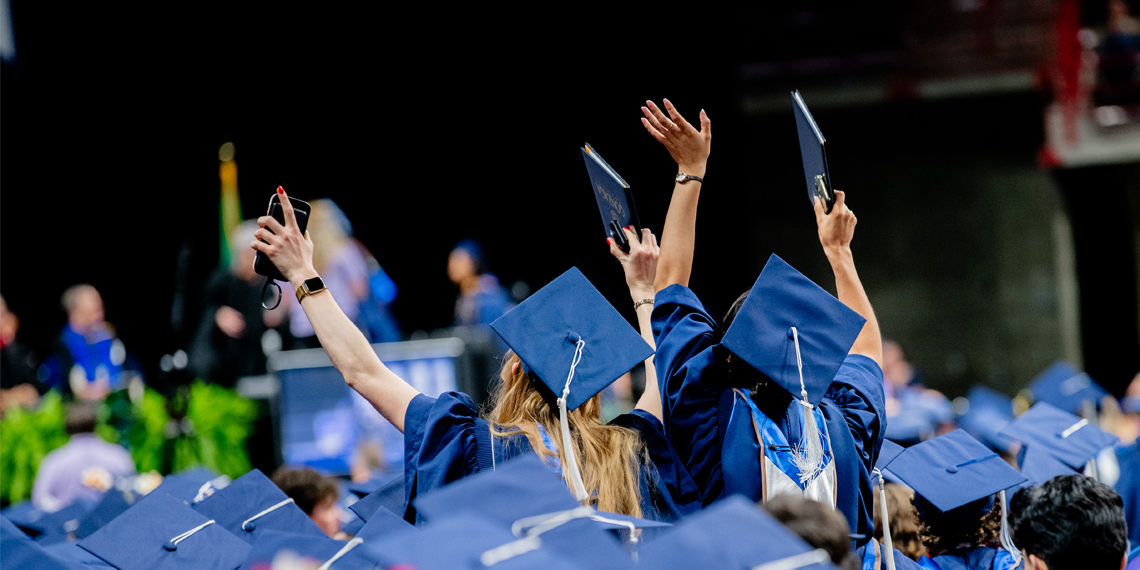 Gonzaga graduates in blue caps and gowns celebrate at the 2026 commencement ceremony.