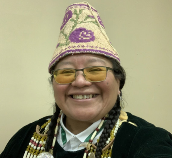 Artist Julie Edwards in traditional Native American accessories and hat.