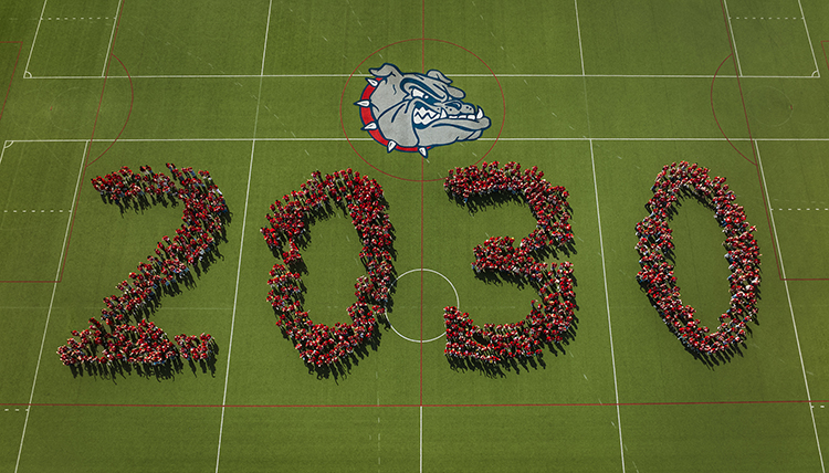 Students on a green field spelling out 2030