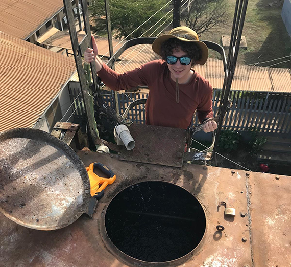 A man in hat behind a manhole
