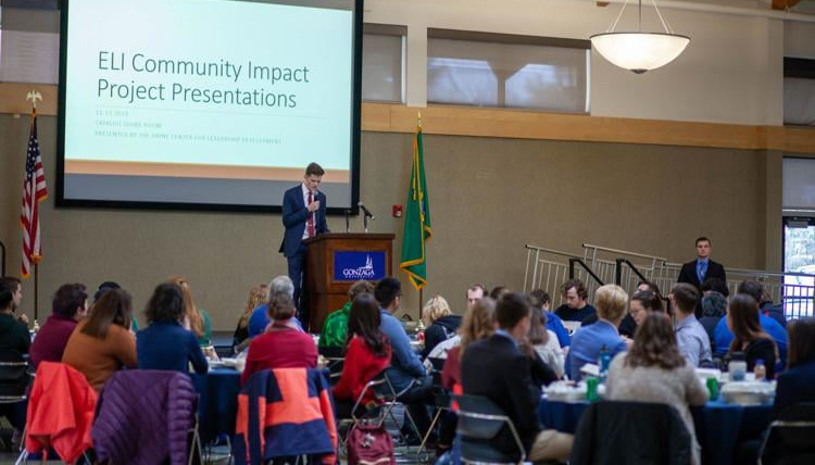 Student presenter in a conference setting with the words, 