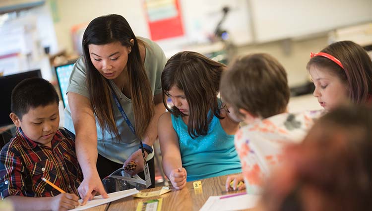 Teacher and students at a table. Teacher and students at a table.