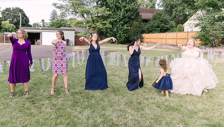 bride with wedding party dancing in the grass bride with wedding party dancing in the grass