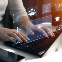A laptop computer with hands on it and icon images in the air above the keyboard. A laptop computer with hands on it and icon images in the air above the keyboard.