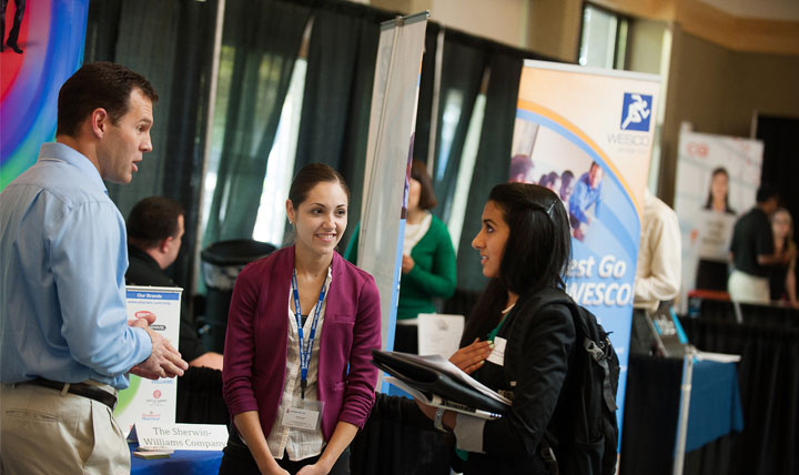 A students speaks with Employers at a Career Fair. A students speaks with Employers at a Career Fair.