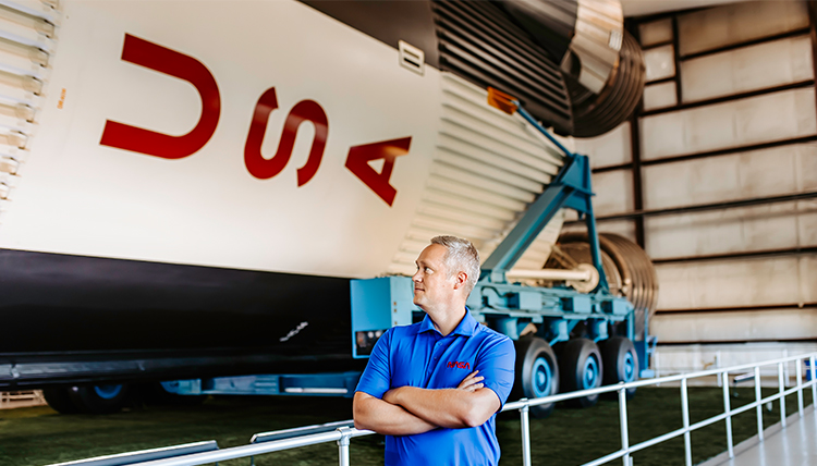 Richard Koelsch standing next to spaceship in hangar. Richard Koelsch standing next to spaceship in hangar.