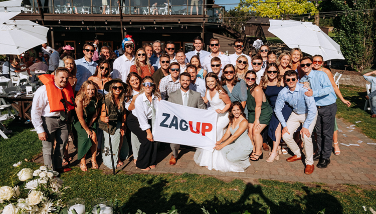 Sabrina Williams and Will Foley with wedding guests holding up a 
