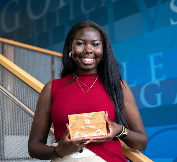 Akon Edwang smiling and holding the Sue Weitz Spirit of Gonzaga Award at Gonzaga University's Magis Awards. Akon Edwang smiling and holding the Sue Weitz Spirit of Gonzaga Award at Gonzaga University's Magis Awards.