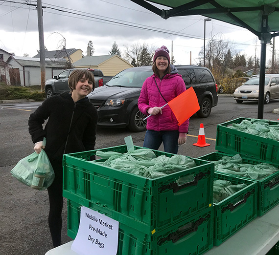 ZoNE Project Director Amber Waldref and volunteers work at a food distribution site in Northeast Spokane