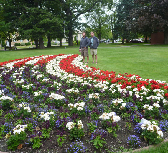 scholarship-jimmy-magnuson-flowers-flag Flowers arranged into the United States flag. Two individuals stand in the