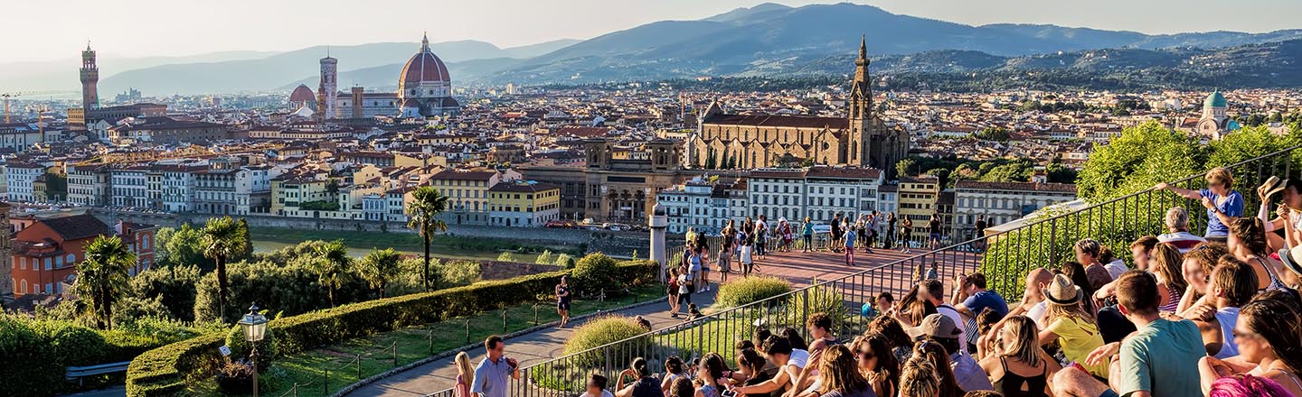 People sitting on hillside in Florence Italy, looking at the cityscape