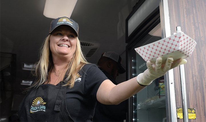 woman serving breakfast from a food truck woman serving breakfast from a food truck