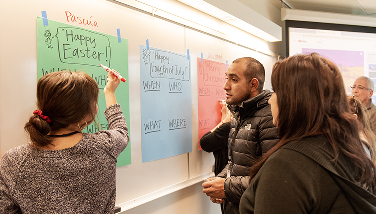 teacher and students review holiday words on a board teacher and students review holiday words on a board