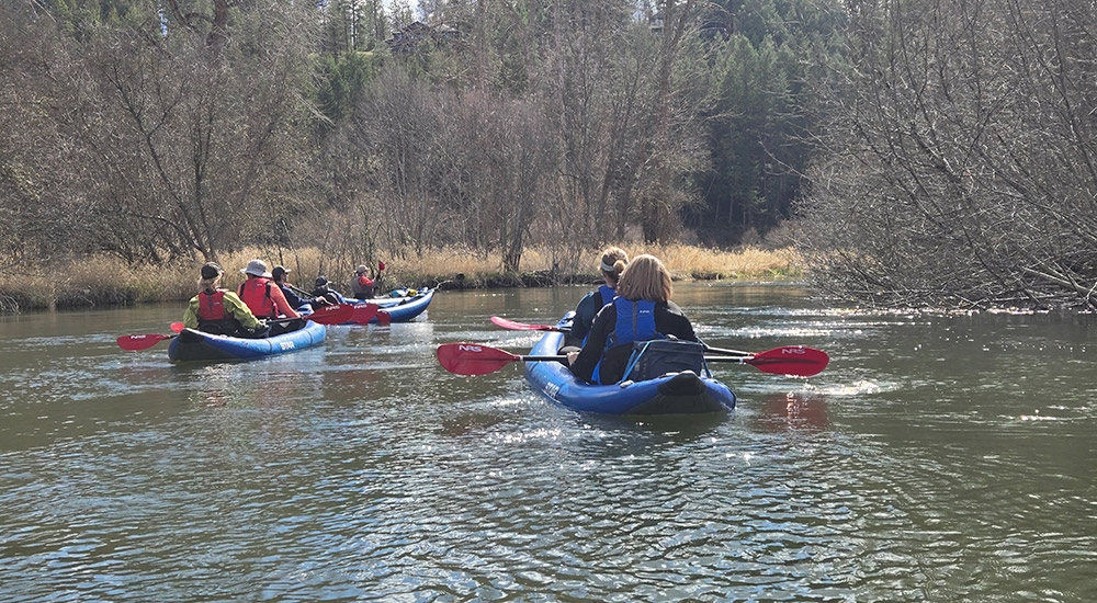 faculty on kayaks in a river faculty on kayaks in a river