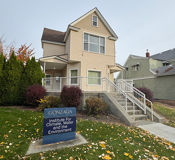 A large yellow house with stairs and white railings