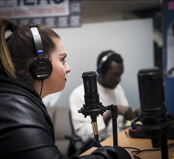 Student close to a microphone recording a podcast. Student close to a microphone recording a podcast.