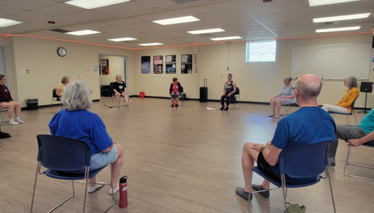 A group seated in a circle in the dance studio ready for group instruction. A group seated in a circle in the dance studio ready for group instruction.
