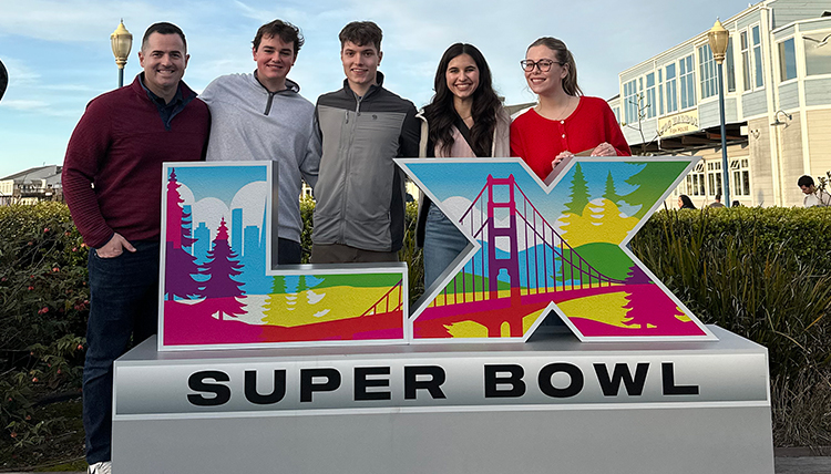 five people stand behind a sign saying Super Bowl five people stand behind a sign saying Super Bowl