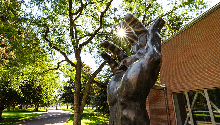 hand of christ sculpture backlit by sun hand of christ sculpture backlit by sun