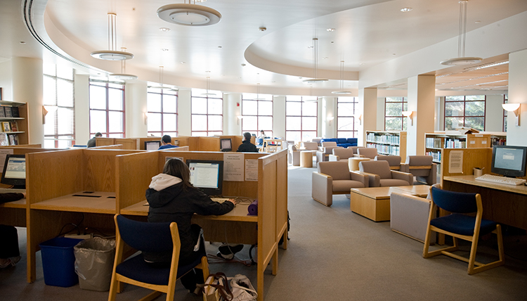 The first floor of Foley Library is shown, with study cubicles and chairs. The first floor of Foley Library is shown, with study cubicles and chairs.