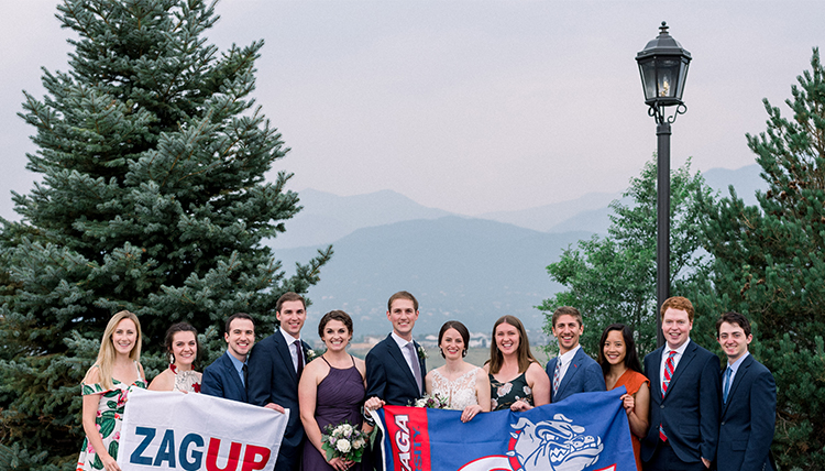 large group of friends and couple with gonzaga flags in front of mountain large group of friends and couple with gonzaga flags in front of mountain