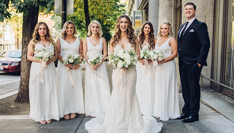 bride surrounded by bridesmaids in white and groom bride surrounded by bridesmaids in white and groom