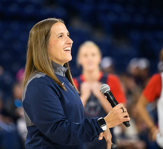 Gonzaga Basketball Coach Lisa Fortier speaking with a microphone in McCarthy Athletic Center
