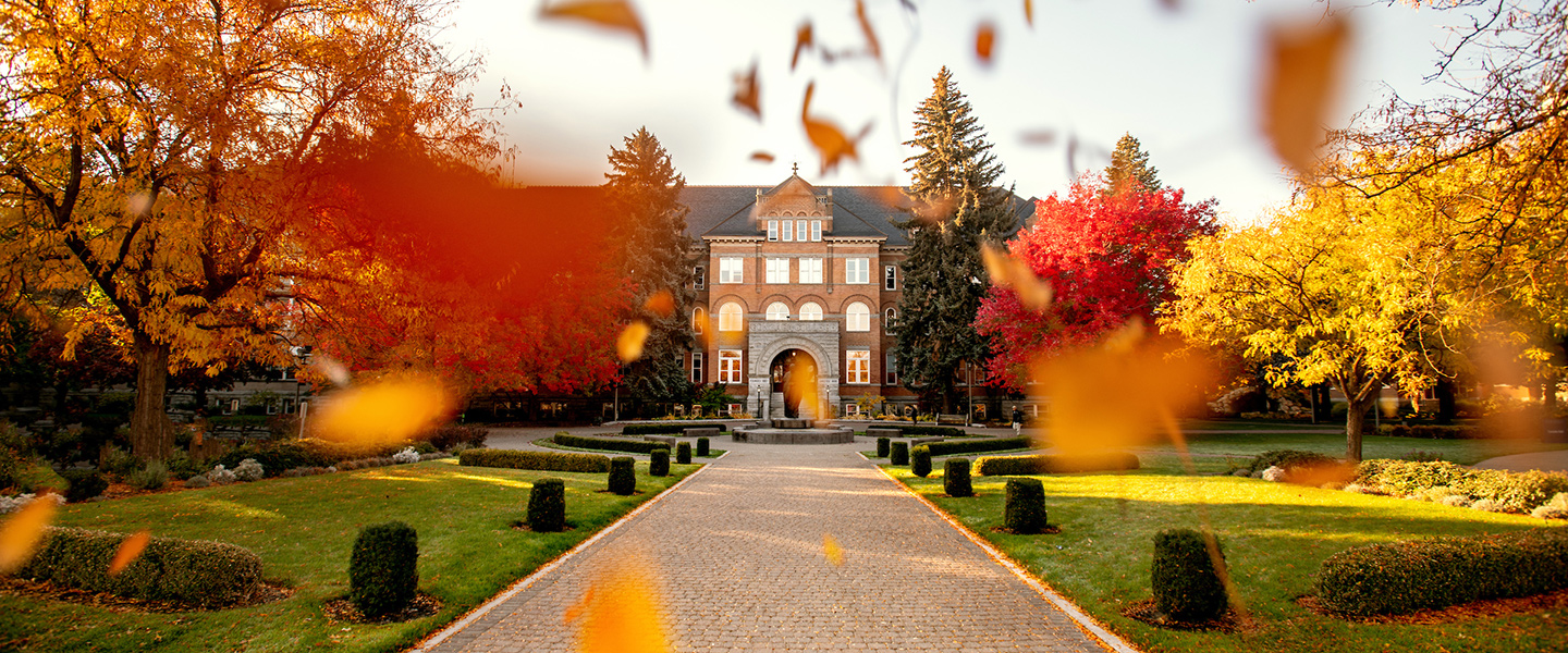 Autumn leaves fall in front of College Hall