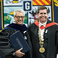 two men dressed in commencement robes two men dressed in commencement robes