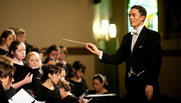 The choir director leads a group of singers. The choir director leads a group of singers.