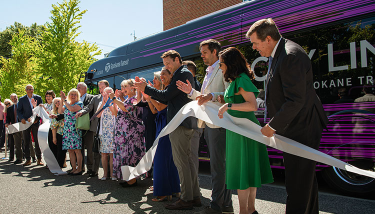 Dignitaries in a line cutting a giant white ribbon Dignitaries in a line cutting a giant white ribbon