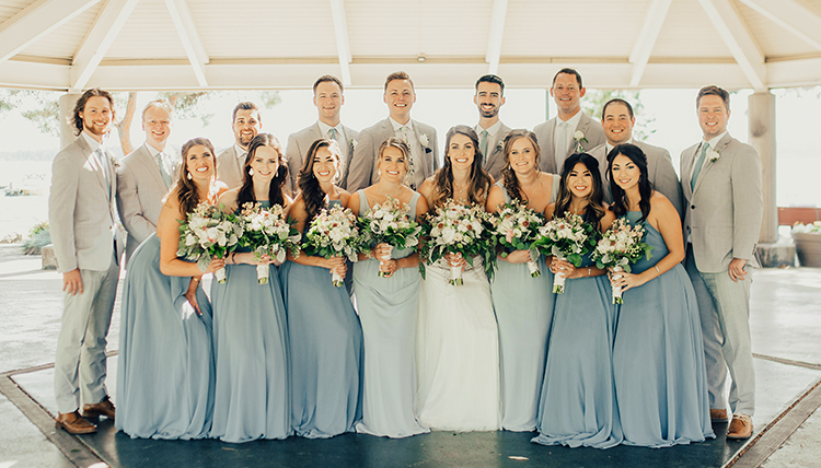 large wedding party with women in blue and men in gray large wedding party with women in blue and men in gray