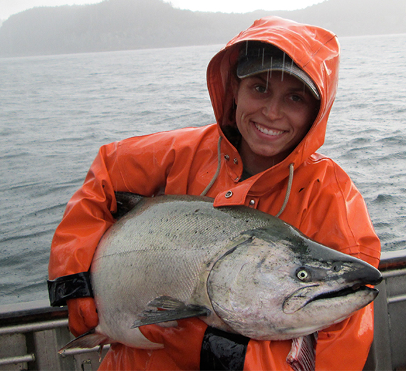 the author in a fishermans jacket holding a large fish