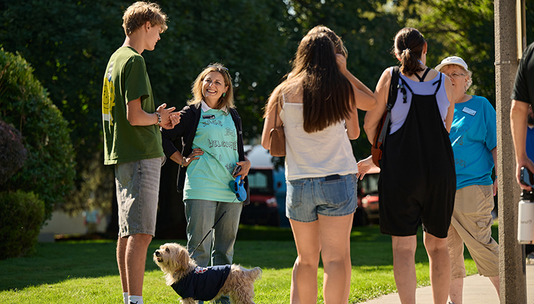 A group of people stand outside talking
