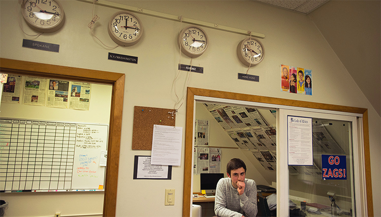 A students leans against a window in the GU Student Media office. A students leans against a window in the GU Student Media office.