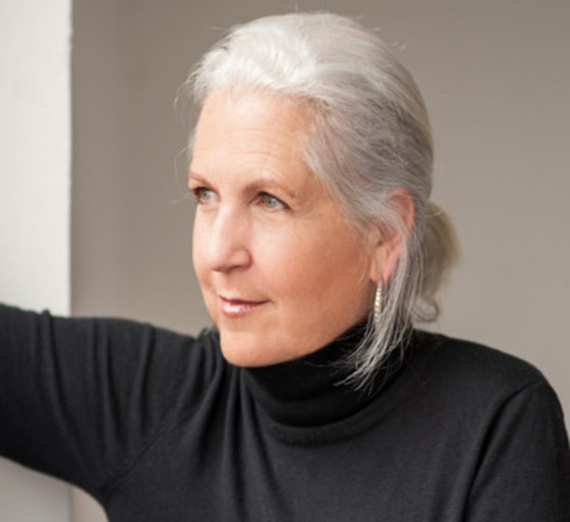 a gray-haired woman in a black turtleneck shirt