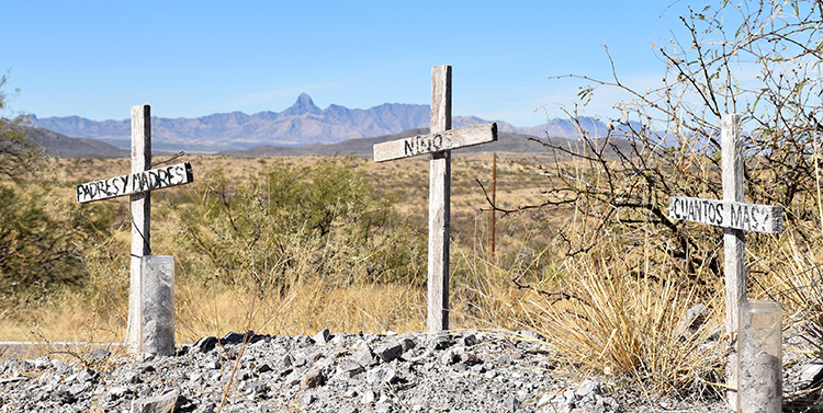 Three commemorative grave markers that read 'Padres y Madres', 'Niños', and '¿Cuantos mas?' Three commemorative grave markers that read 'Padres y Madres', 'Niños', and '¿Cuantos mas?'
