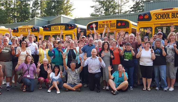 Group of educators in front of busses, cheering Group of educators in front of busses, cheering