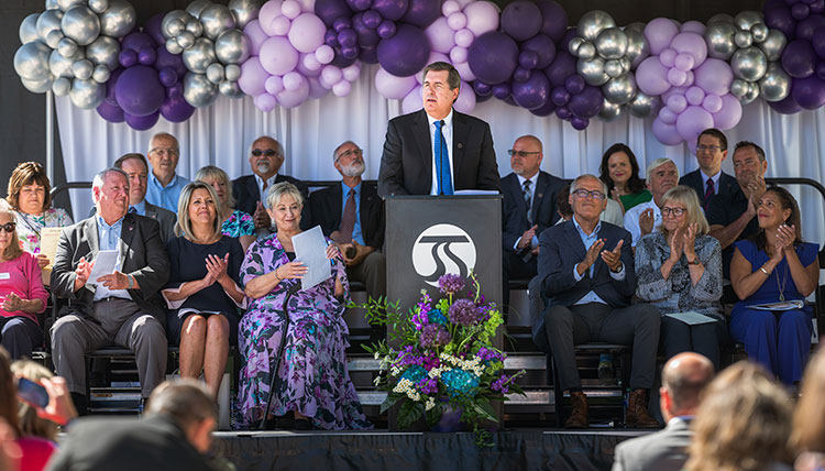 Gonzaga President Thayne McCulloh speaking at a podium, surrounded by visiting dignitaries Gonzaga President Thayne McCulloh speaking at a podium, surrounded by visiting dignitaries