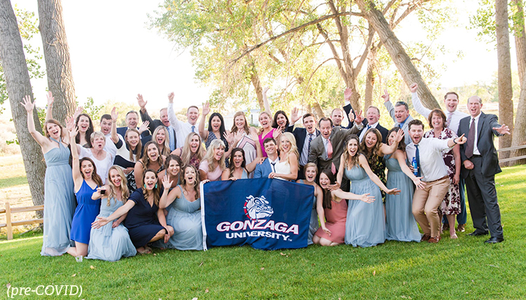 Large group poses in behind Gonzaga flag Large group poses in behind Gonzaga flag
