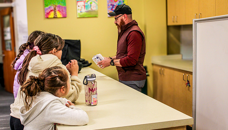 A man teaching kids in a kitchen. A man teaching kids in a kitchen.