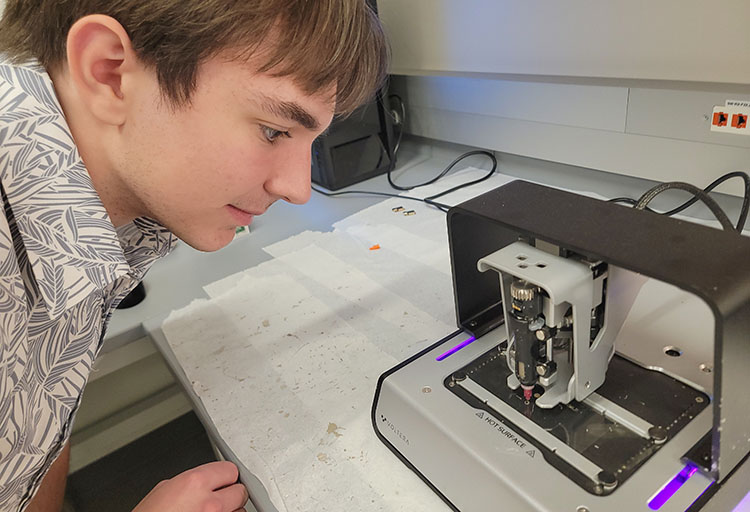 Biomed-2026-0603_142107_Jordan_printer-bd A young man looks at a small piece of equipment