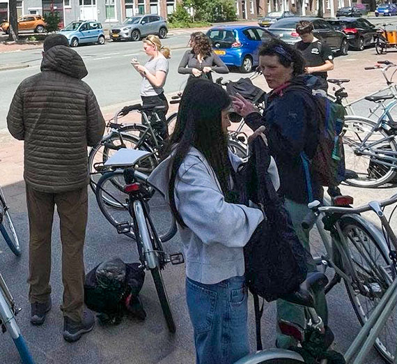 students check directions on their phones and pick up their bicycles.