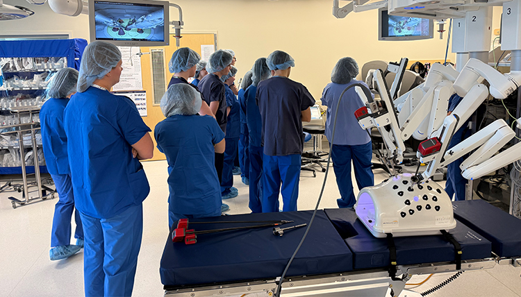 students in a hospital surgery suite with robotic device