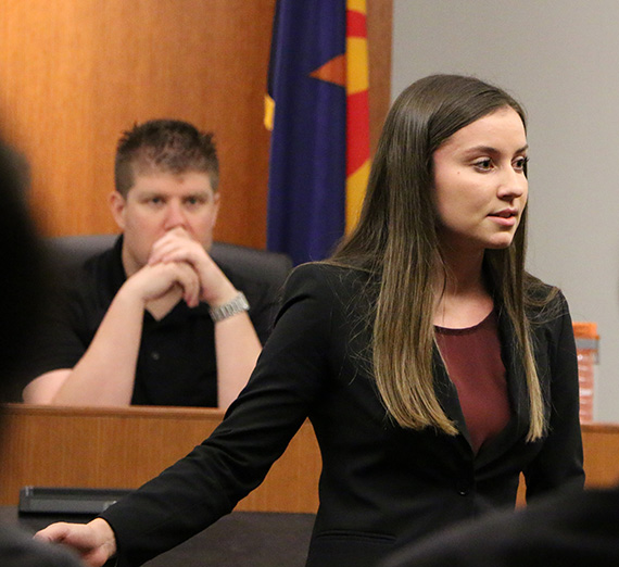 Sarah Kohan stands in front of a mock trial court room. Sarah Kohan stands in front of a mock trial court room.