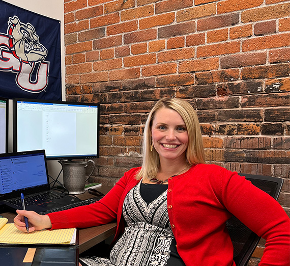 Alumna Melissa Koontz, class of 2012, sits at desk