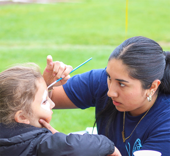 A woman paints a child's face