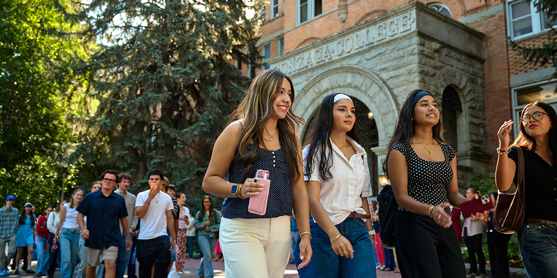 Students walking outside in front of building with Gonzaga College over the door