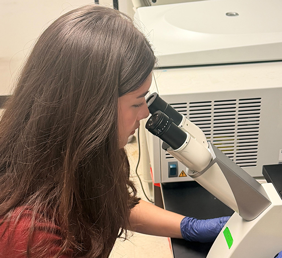 Woman looking into a microscope.