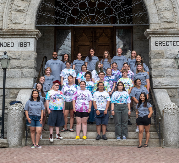 Group of staff, students, and high school youth posing on the steps of College hall. Group of staff, students, and high school youth posing on the steps of College hall.